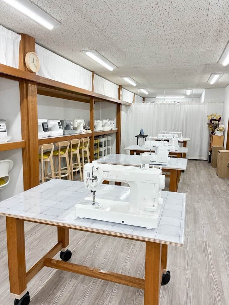 作業台に置かれた職業用ミシンと、奥まで続く Nippori Share Base の作業スペース